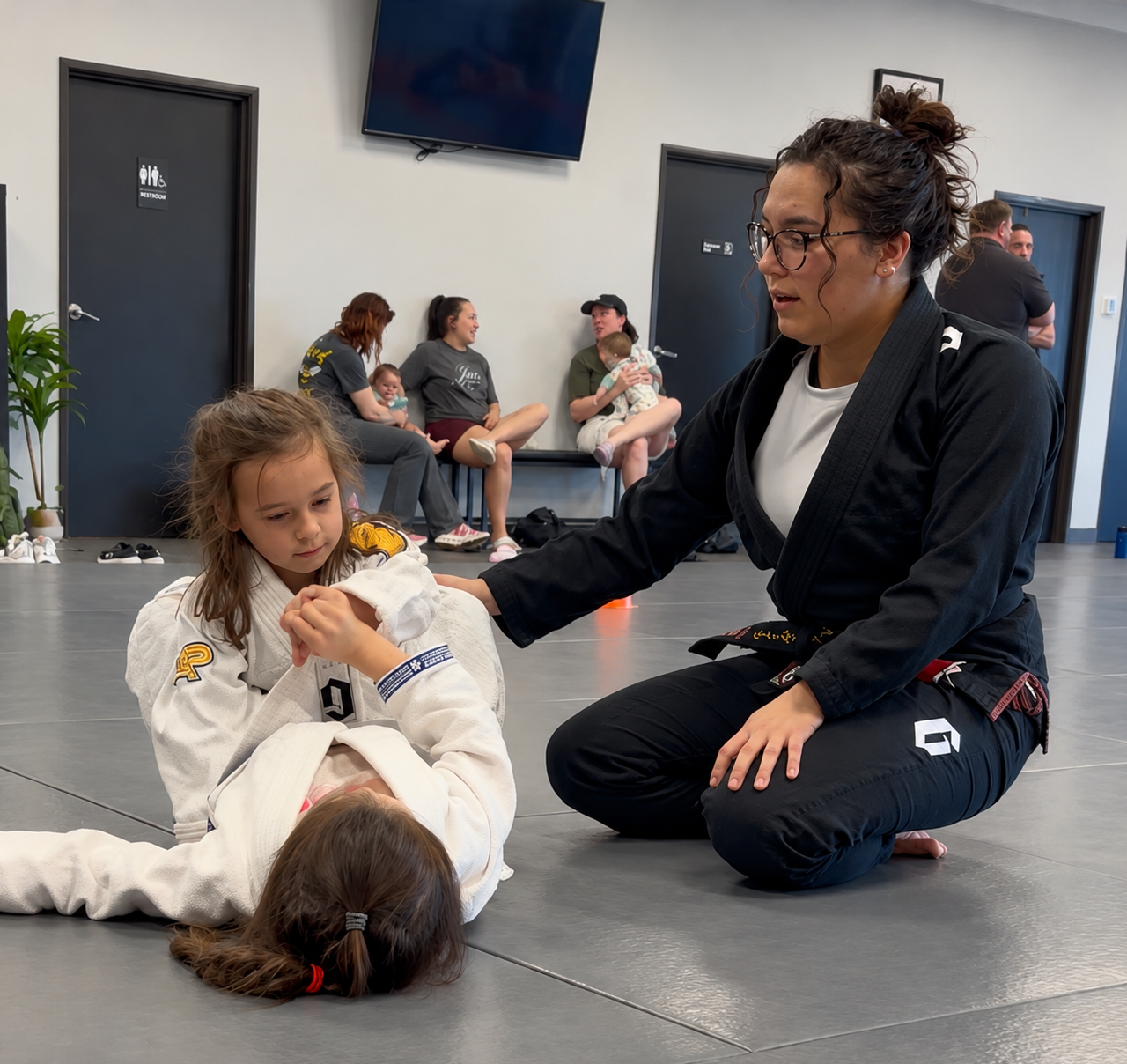 Instructor guiding children through Brazilian Jiu-Jitsu practice at Soul Fighters