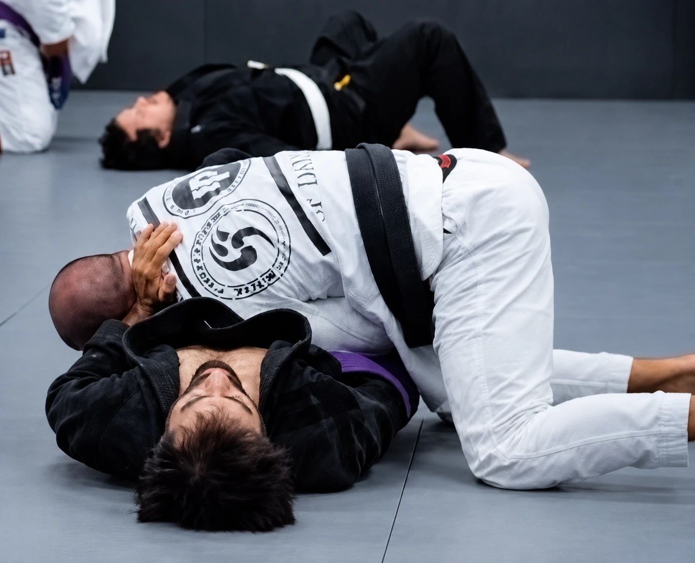 Students practicing Brazilian Jiu-Jitsu on the mat at Soul Fighters